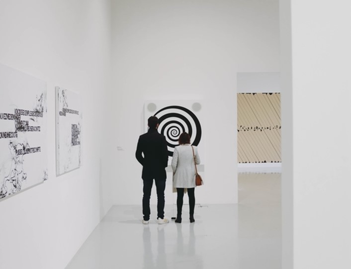 Two people looking at artwork in a museum