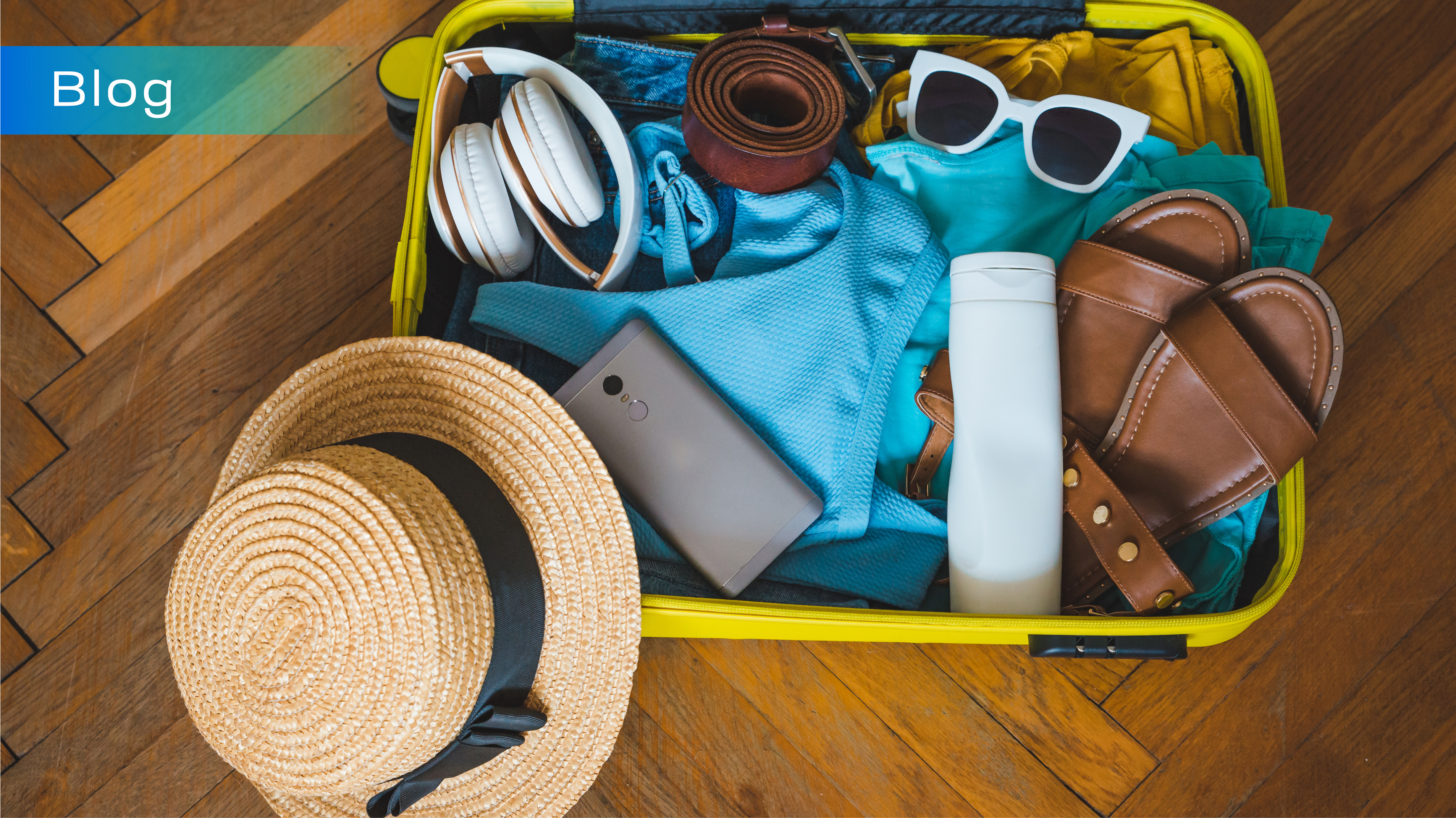 Packed yellow suitcase with straw hat