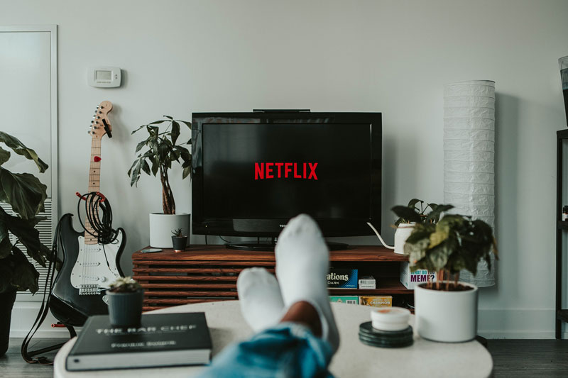 OTT platform, someone watching connected tv with their feet up